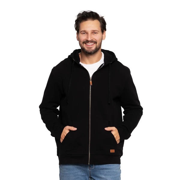Uśmiechnięty mężczyzna w czarnej bluzie z kapturem na zamek, dżinsach i białym T-shircie na białym tle.