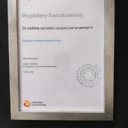 Dyplom w srebrnej ramce dla Magdaleny Kwiatkowskiej za wybitną sprzedaż ubezpieczeń grupowych, wydany przez Dyrekcję Krajową Łukasza Junika z logo Nationale Nederlanden.