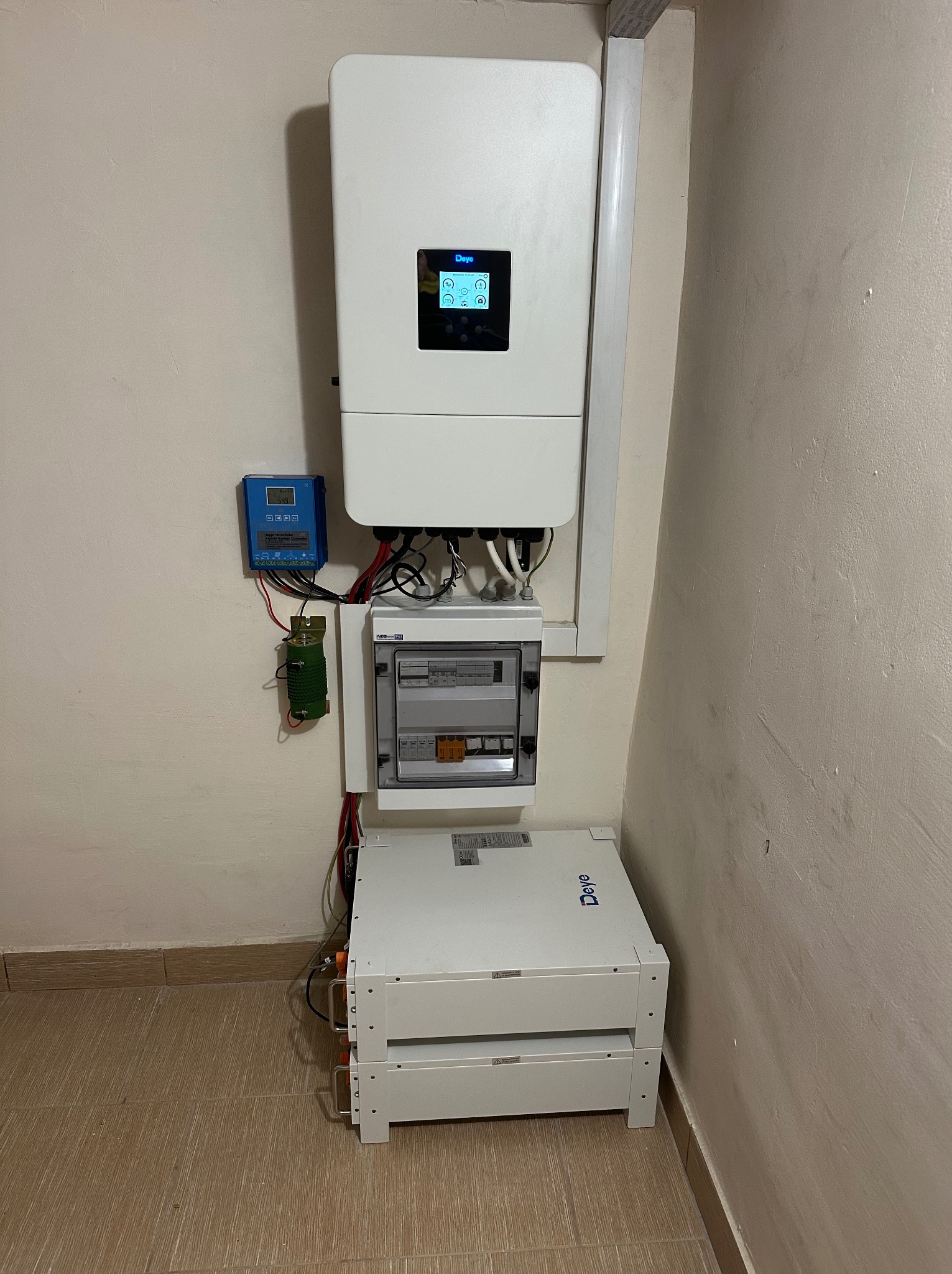 Kompletna instalacja fotowoltaiczna wewnątrz budynku: inwerter Deye, magazyn energii, rozdzielnica i kontroler. Widoczne okablowanie i elementy montażowe.