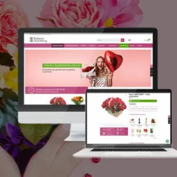 Ekran monitora i laptopa prezentujące stronę internetową kwiaciarni z motywem różowych kwiatów w tle. Na stronie głównej widoczna kobieta z czerwonym balonem w kształcie serca i bukietem róż.