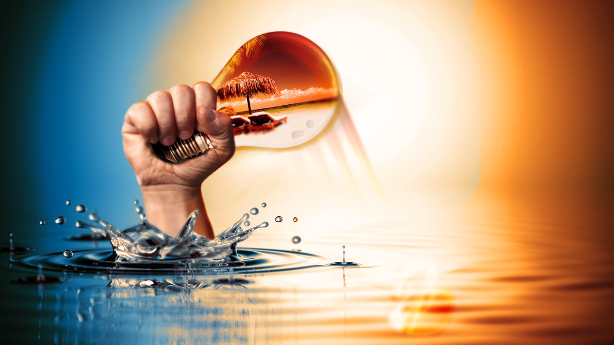 Ręka trzymająca żarówkę z plażą w środku, woda rozpryskuje się u podstawy żarówki.