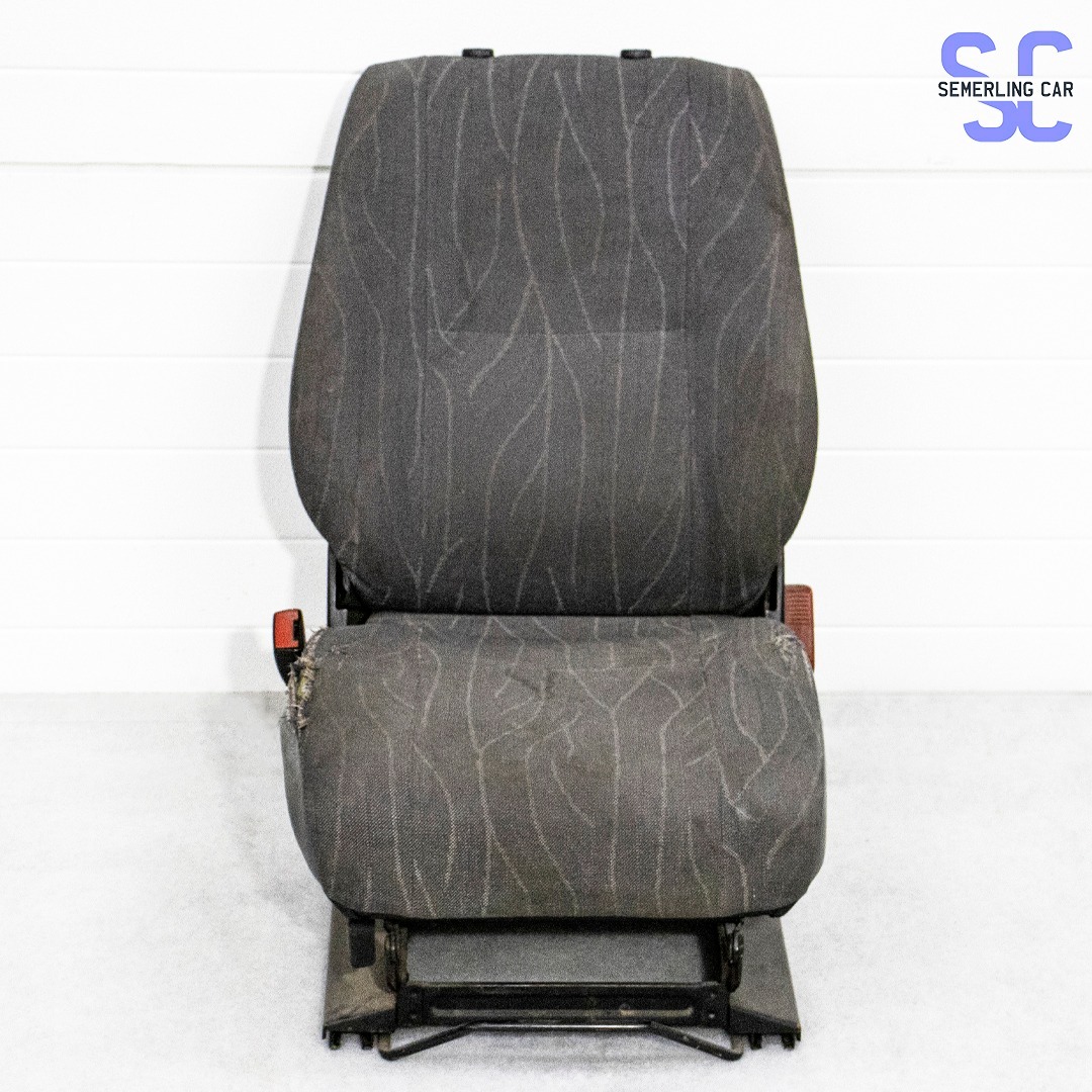 Używane, szare siedzenie samochodowe z wzorem przypominającym gałązki, widoczne przetarcia na boku siedziska, czerwony element pasów bezpieczeństwa.
