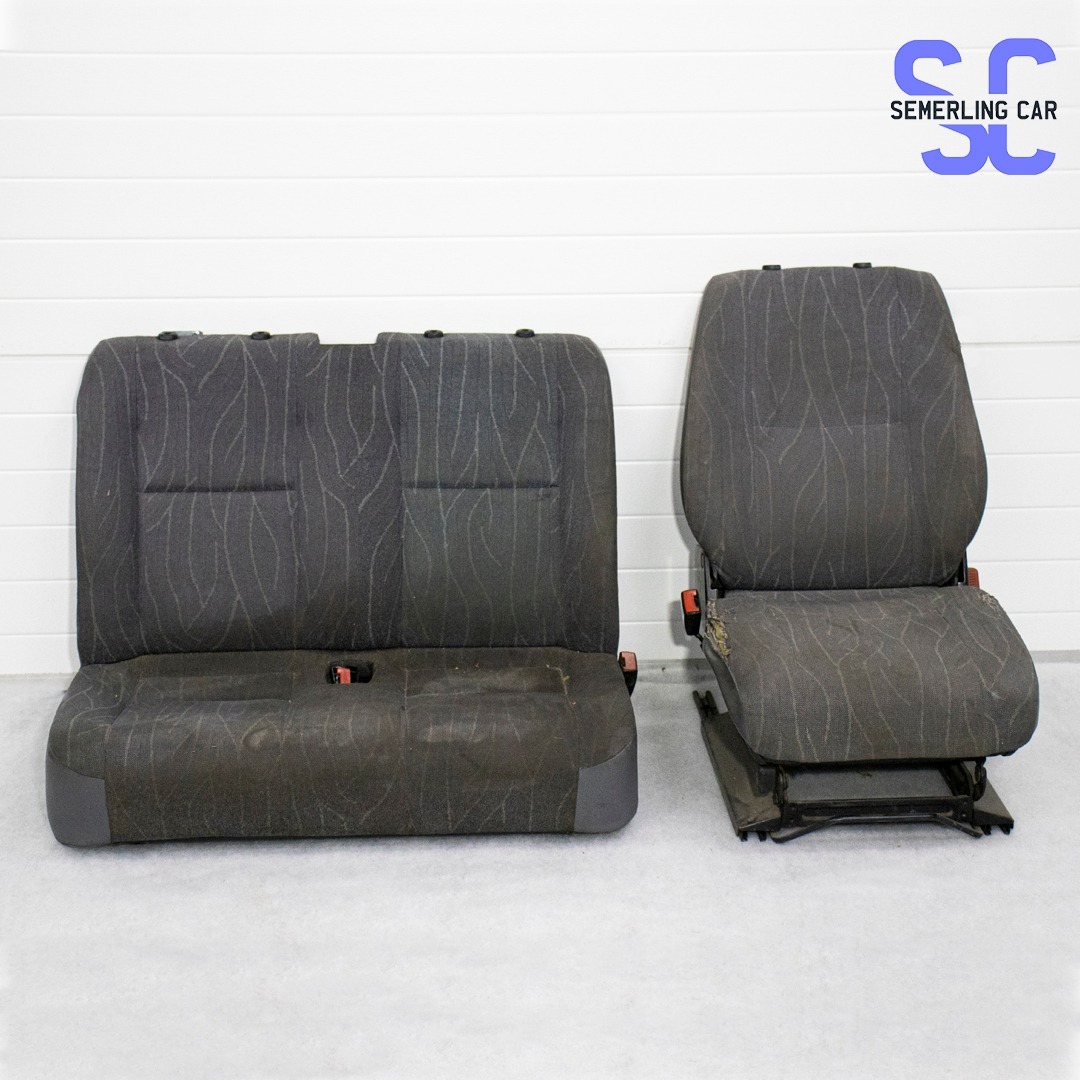 Dwa używane, szare fotele samochodowe z materiałową tapicerką o wzorze przypominającym gałązki, widoczne ślady zużycia i drobne uszkodzenia.
