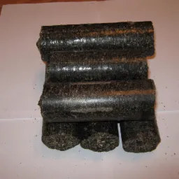 Ułożone w stos brykiety drzewne z widoczną strukturą włókien, prezentowane na białym tle w Dnepropetrovsku.