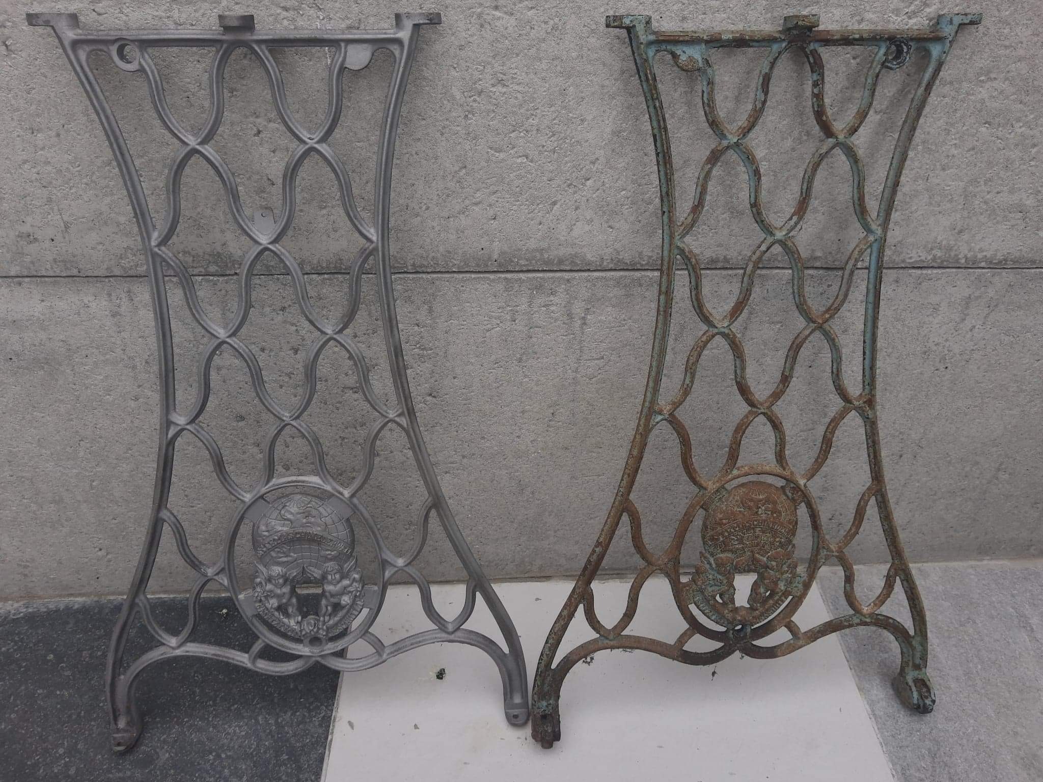 Porównanie: odrestaurowana, szara, metalowa podstawa maszyny do szycia po lewej, obok zardzewiałej, niebiesko-brązowej podstawy przed renowacją, obie z dekoracyjnym motywem aniołków i globu.