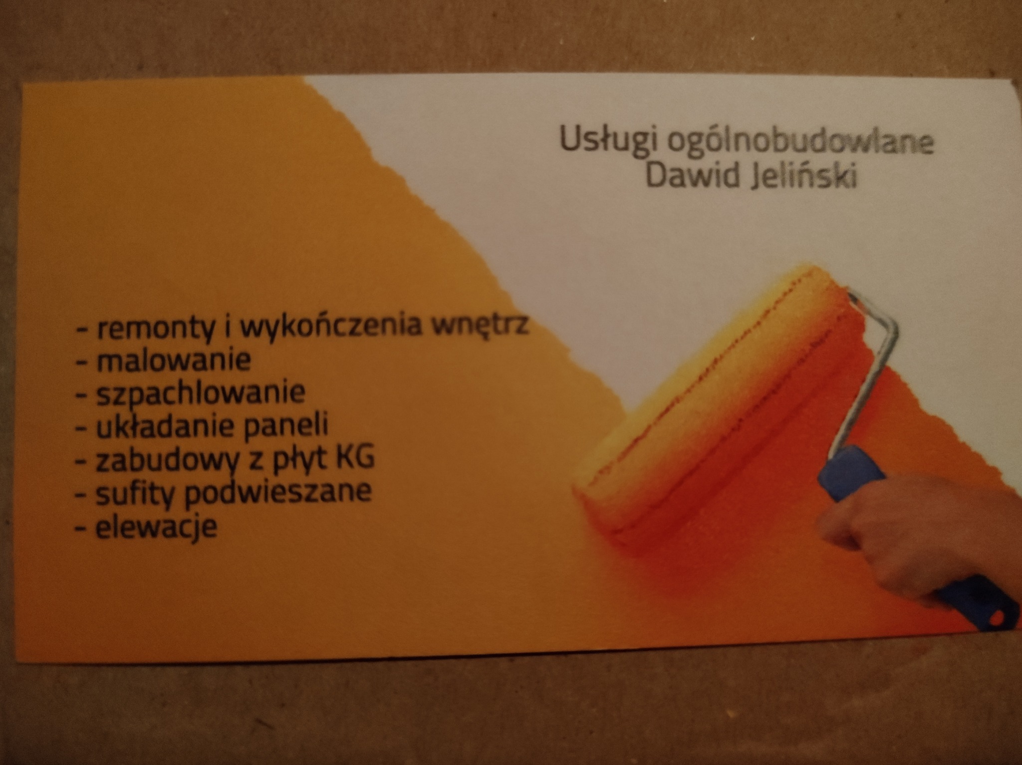 Wizytówka firmy remontowo-budowlanej Dawid Jeliński, oferującej usługi malowania, szpachlowania, układania paneli, zabudowy z płyt KG, sufity podwieszane i elewacje, z motywem wałka malarskiego...
