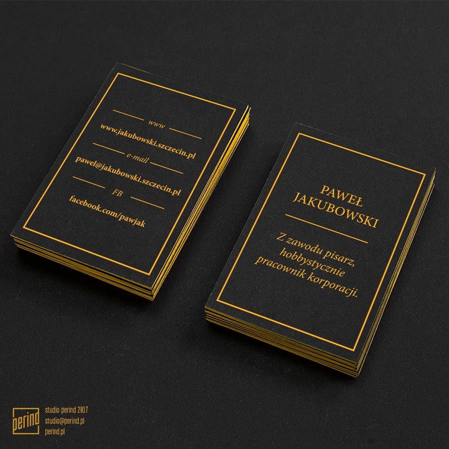 Elegancki projekt wizytówki w kolorze czarnym ze złotymi detalami, prezentujący dane kontaktowe i zawód autora książek fantasy, ułożony w stos obok drugiej wizytówki na ciemnym tle.