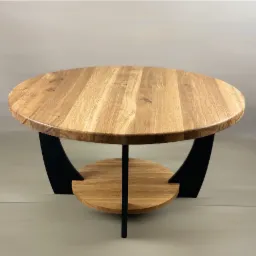 Okrągły stolik kawowy z blatem z jasnego drewna dębowego i czarnymi, zakrzywionymi nogami, z dodatkową półką pod blatem.