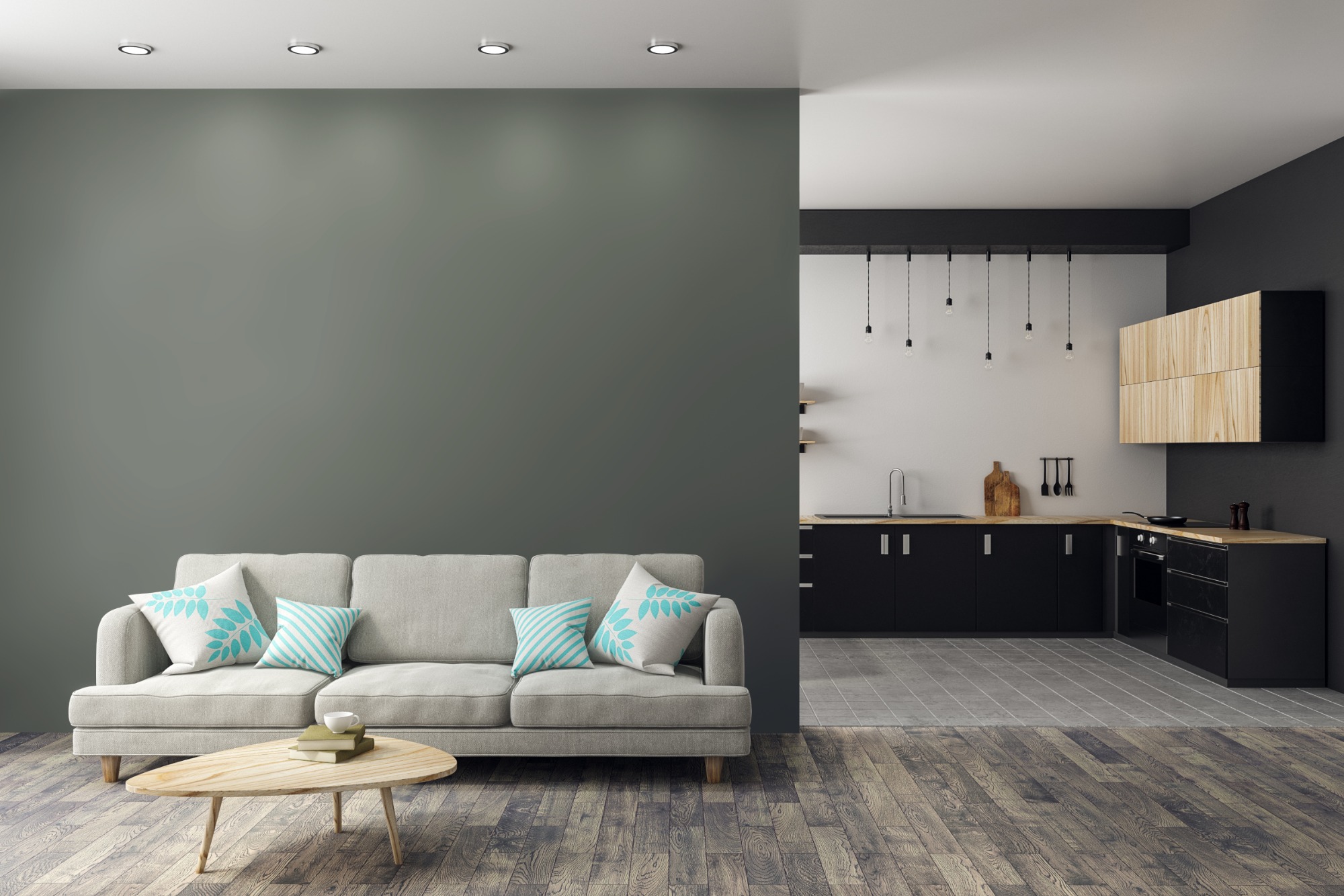 Wnętrze mieszkania: szara ściana, sofa z poduszkami w odcieniach błękitu, drewniany stolik kawowy z książkami i filiżanką, w tle otwarta kuchnia z czarnymi szafkami i drewnianymi blatami.