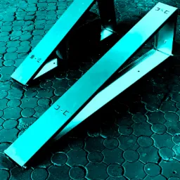 Dwa stalowe stojaki rowerowe w kształcie litery A, ustawione na brukowanej powierzchni z okrągłymi wzorami, widziane z góry pod kątem.