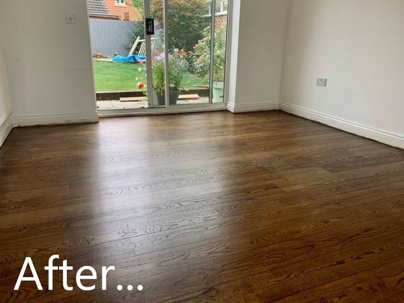 Polakierowany parkiet z wyraźnym rysunkiem drewna w jasnym pokoju z widokiem na ogród przez przesuwne drzwi.