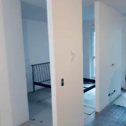 Montaż ścianki działowej z płyt kartonowo-gipsowych, widoczne profile i wstępnie zagruntowana powierzchnia, przygotowana do dalszych prac wykończeniowych.