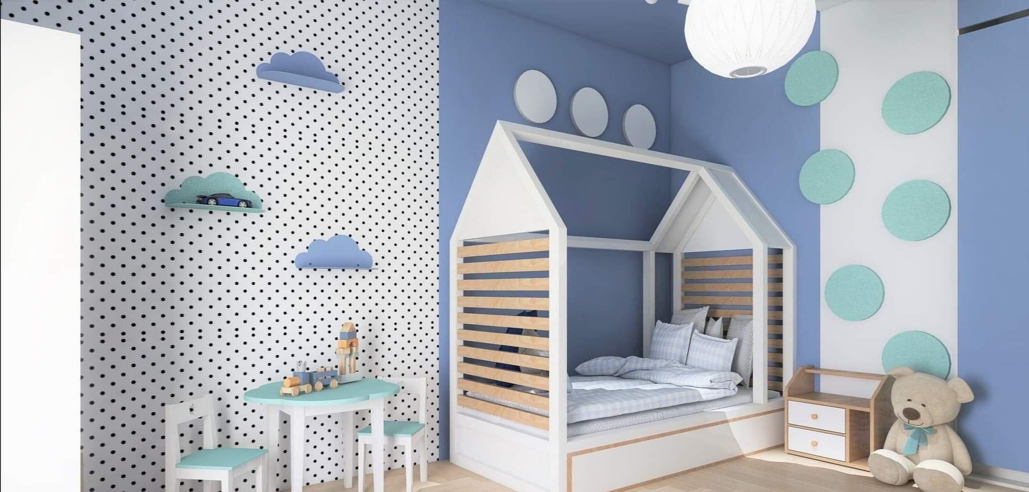 Pokój dziecięcy w odcieniach błękitu z łóżkiem w kształcie domku, białymi meblami i ścianą w czarne kropki, udekorowaną półkami w kształcie chmur, na których stoi model samochodu.