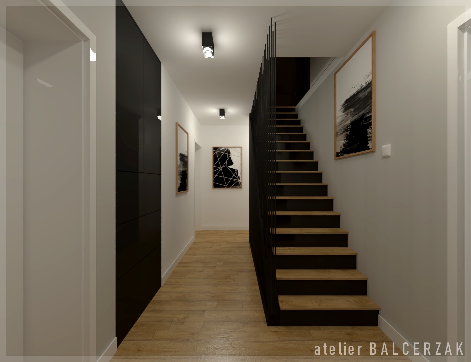 Wnętrze korytarza z drewnianą podłogą, czarną zabudową szaf, schodami z czarną balustradą i obrazami na ścianach.