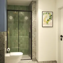 Nowoczesna łazienka z kabiną prysznicową wyłożoną zielonymi, kwadratowymi płytkami, toaleta podwieszana z uchwytem na papier toaletowy i plakat 'La Botanique' na białej ścianie.