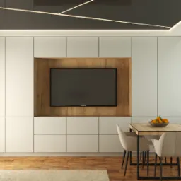 Nowoczesna aranżacja salonu z zabudową meblową w kolorze ecru, drewnianą wnęką na telewizor Samsung, stolikiem z owocami i parkietem na podłodze.