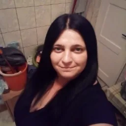 Autoportret kobiety z długimi, czarnymi włosami, na tle łazienki z wiadrem i mopem