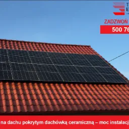 Panele na dachu pokrytym czerwoną dachówką ceramiczną, z logo firmy i numerem telefonu. Moc instalacji 3,96 kWp.