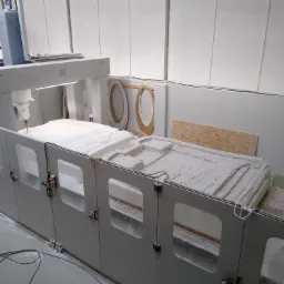 Frezarka CNC w Białymstoku w trakcie obróbki formy, widoczne elementy drewniane w tle, oświetlenie przemysłowe.