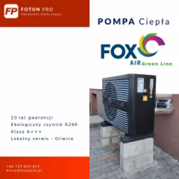 Czarna pompa ciepła marki FOX Air Green Line, zamontowana na betonowych bloczkach na zewnątrz budynku, z widocznymi rurami instalacyjnymi; informacja o 10-letniej gwarancji, ekologicznym czynniku...