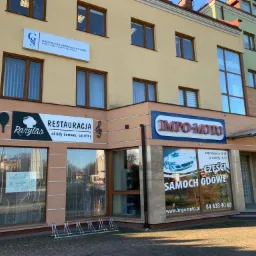 Zewnętrzny widok budynku z szyldem 'Magdalena Grabias-Gontarz Kancelaria Radcy Prawnego' nad restauracją 'Rarytas' oferującą obiady domowe i catering, oraz sklepem motoryzacyjnym 'Impo-Moto'...