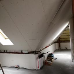 WNB Decor - Poddasze w trakcie wykańczania płytami kartonowo-gipsowymi, widoczne szpachlowane łączenia i okno dachowe, na podłodze narzędzia i materiały budowlane.