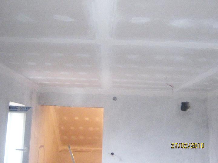 Poddasze w trakcie adaptacji: sufit i ściany wykończone płytami gipsowo-kartonowymi, widoczne łączenia płyt przed szpachlowaniem, wystające przewody elektryczne, przygotowany otwór drzwiowy.