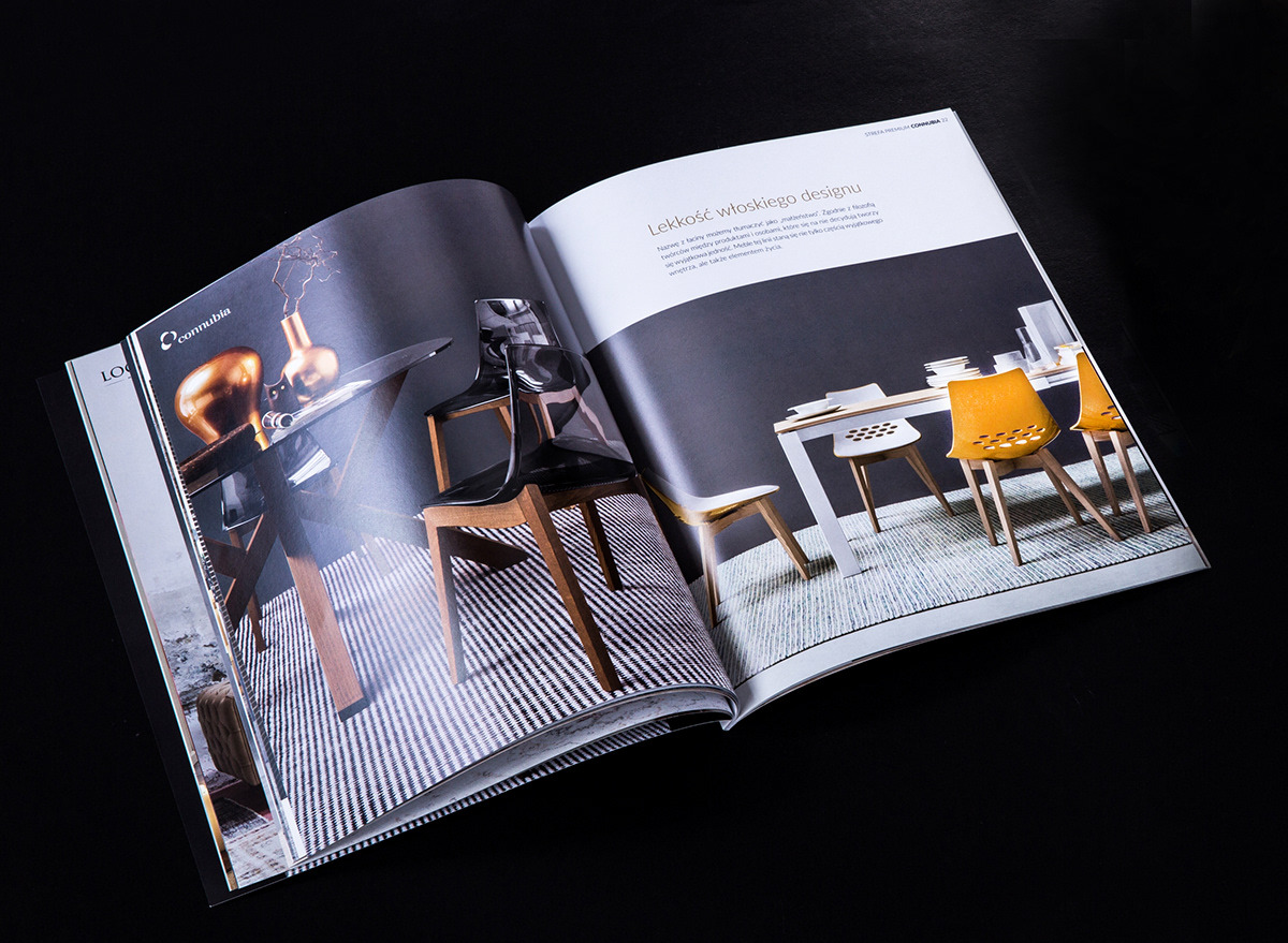 Rozłożony magazyn prezentujący aranżacje wnętrz z nowoczesnymi meblami: szklany stół z dekoracyjnym wazonem i krzesłami z przezroczystego tworzywa, obok biały stół z kolorowymi krzesłami na dywanie.