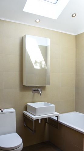 Nowoczesna łazienka w Lublinie z kwadratową umywalką na chromowanym stelażu, lustrem w szafce i oknem dachowym w suficie.