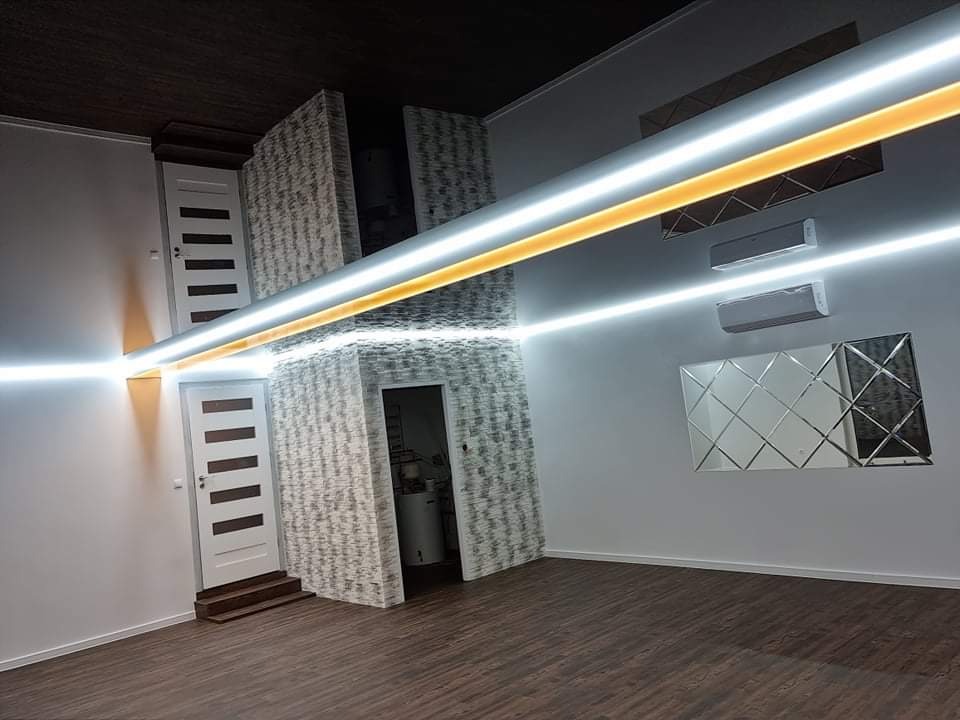 Wykończone wnętrze w Kuczbork-Osadzie z podwieszanym sufitem z lustrzanym odbiciem, oświetleniem LED, panelami ściennymi imitującymi cegłę, lustrzaną dekoracją ścienną i dwoma klimatyzatorami.