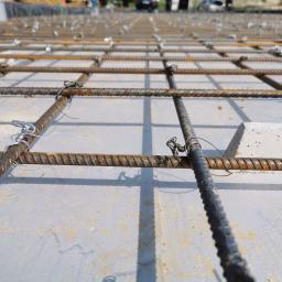 www.domyzkeramzytu.pl-Krotoszyn - Zbrojenie płyty fundamentowej z betonu, siatka z prętów stalowych połączonych drutem wiązałkowym, widok z bliska na konstrukcję przed zalaniem betonem.