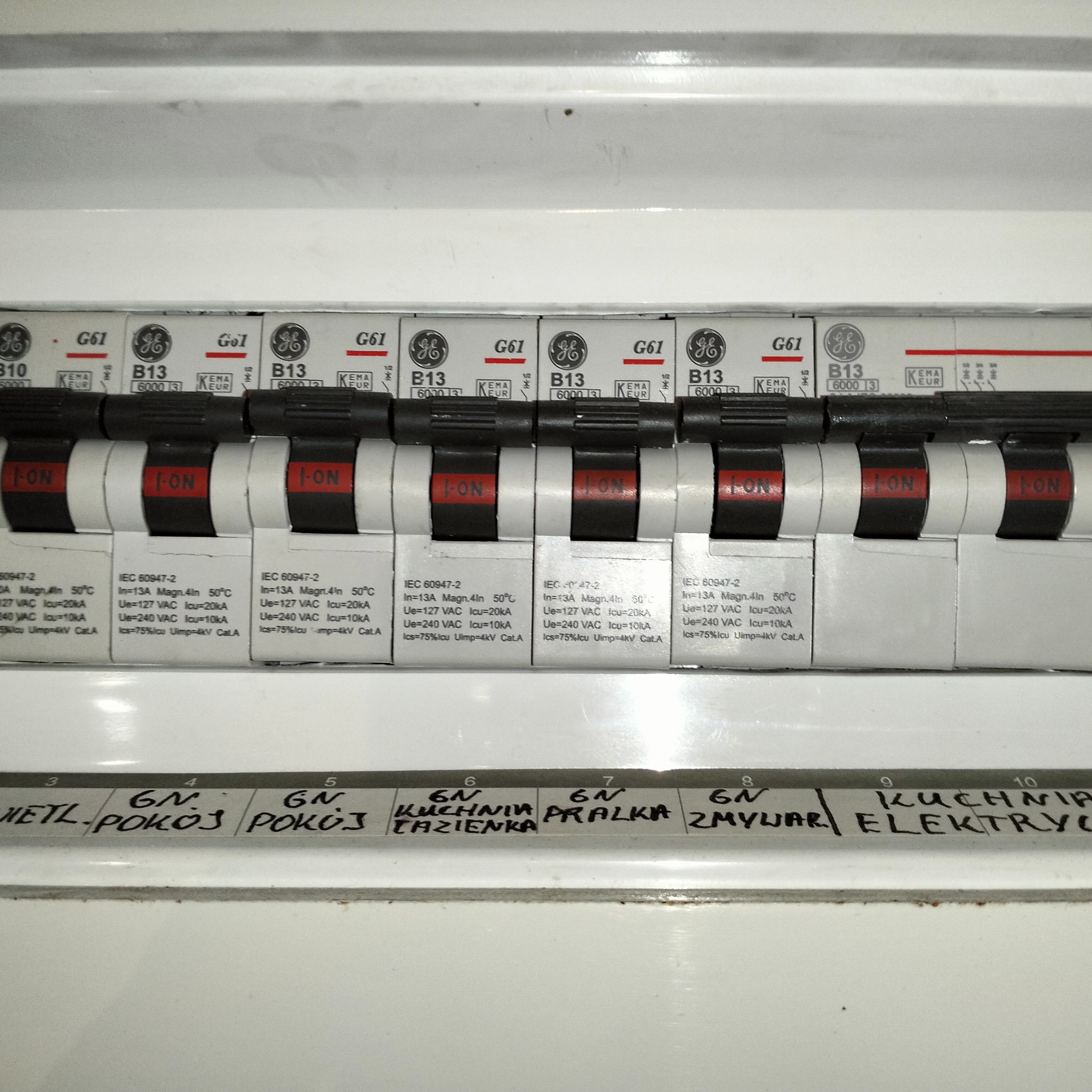 Tablica rozdzielcza z wyłącznikami nadprądowymi, opisane obwody: Wietl-Pokoj, Pokoj, Kuchnia/Łazienka, Pralka, Zmywarka, Kuchnia Elektryczna.