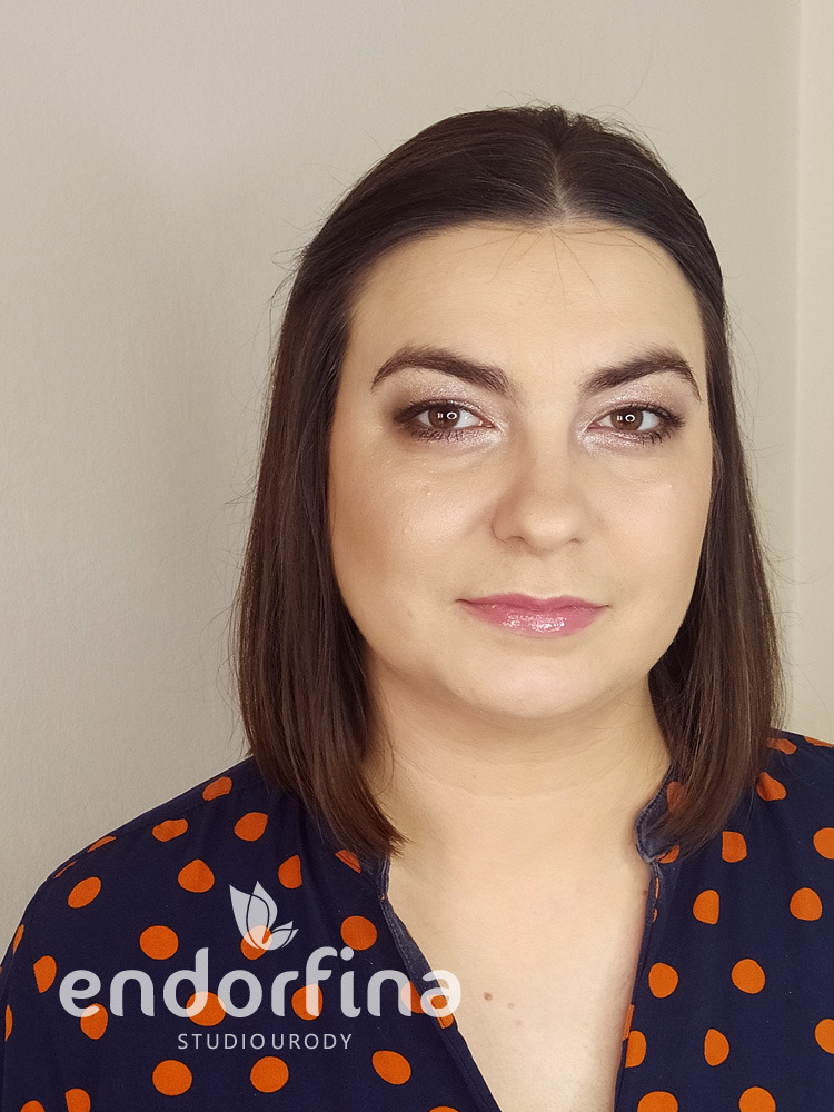 Portret kobiety z delikatnym makijażem dziennym, uwydatniającym oczy i usta. Subtelne cieniowanie powiek i błyszczący róż na ustach. Logo salonu w lewym dolnym rogu.