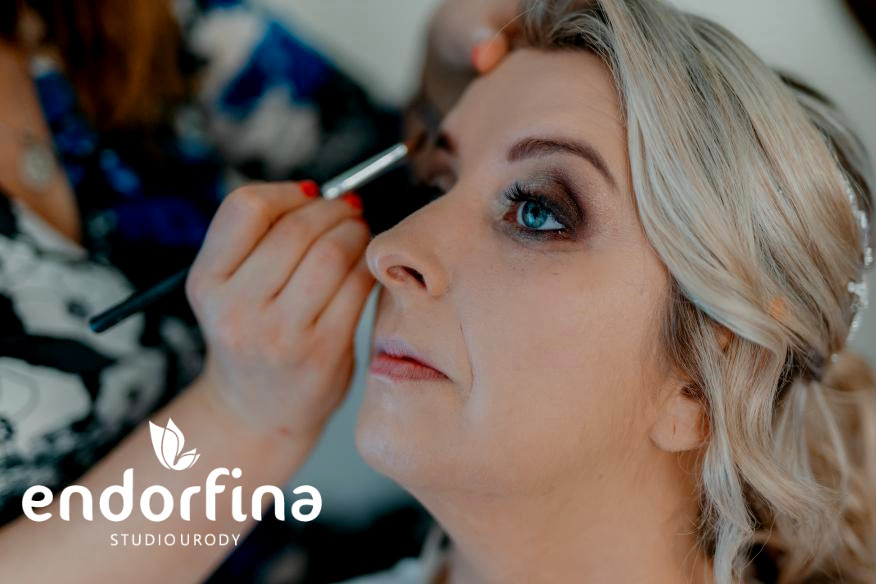 Profesjonalny makijaż oka wykonywany pędzlem, podkreślający niebieską tęczówkę. Subtelne upięcie włosów dopełnia wizerunek. Studio urody Endorfina.