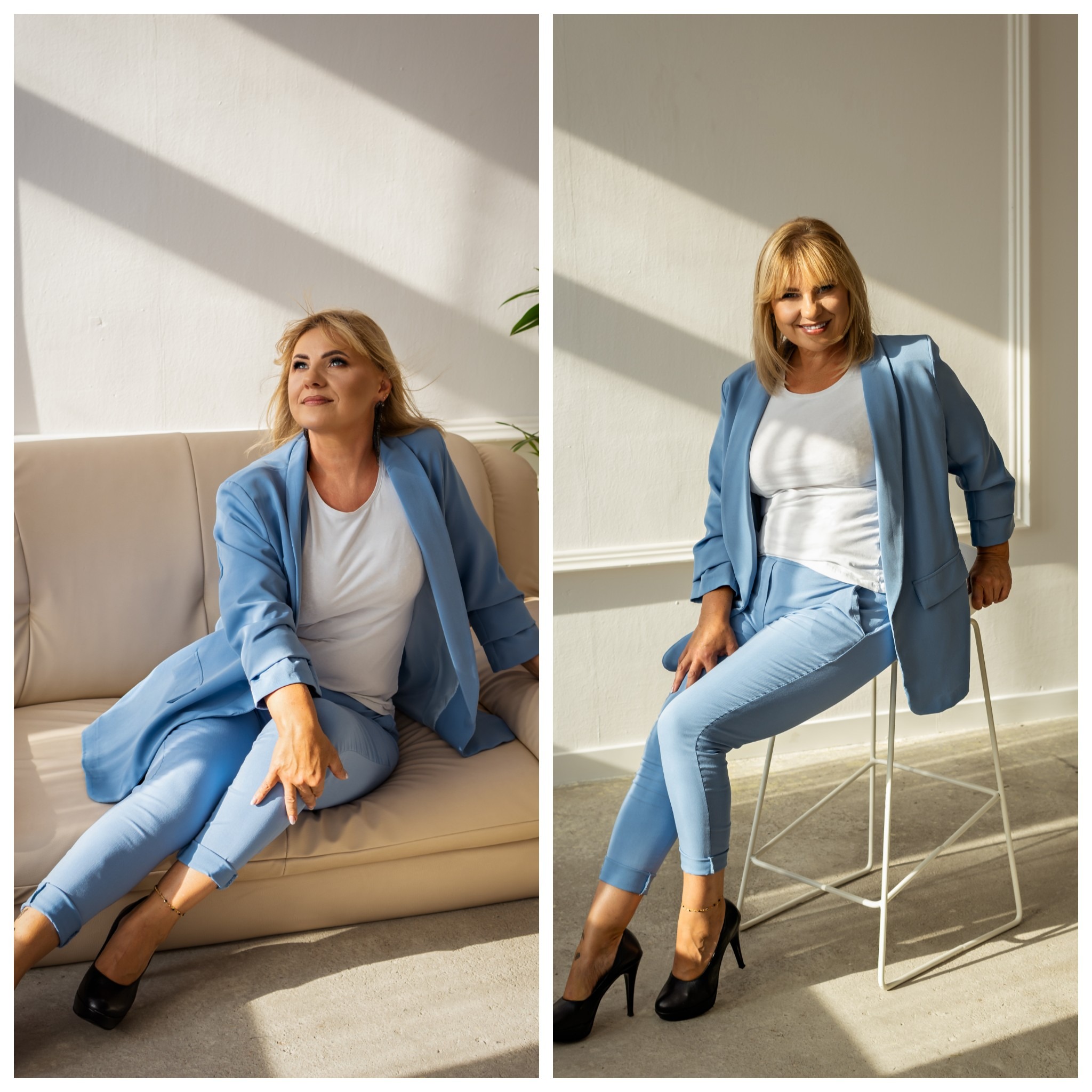 Kobieta w błękitnym garniturze, pozująca w studio na beżowej sofie i na białym krześle barowym, z promieniami słonecznymi na ścianie.