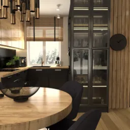 Wizualizacja jadalni z okrągłym stołem z drewnianym blatem, czarnymi krzesłami i dekoracyjnymi misami. W tle czarna zabudowa kuchenna z drewnianymi elementami, witryna z podświetleniem i zegar...