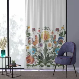 Wzorzysta zasłona z motywem kogutów i kwiatów w stylu ludowym, ustawiona w pokoju obok designerskiego krzesła z fioletową tapicerką.