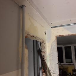 Adrian Maśny - Przygotowanie otworu drzwiowego: obróbka muru, montaż profili pod płytę gipsowo-kartonową, widoczne rury instalacyjne.