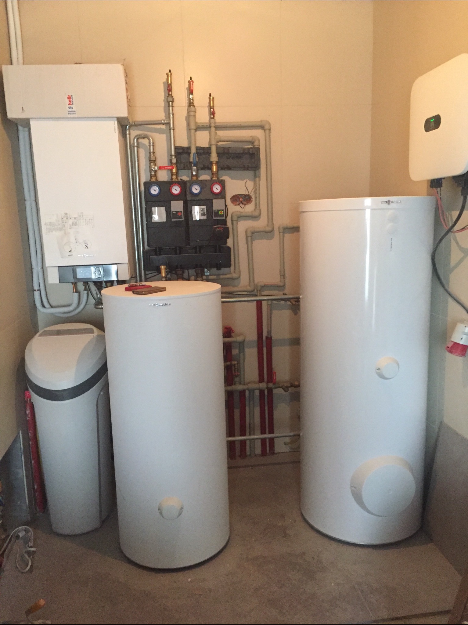 Kompletna instalacja grzewcza z dwoma zasobnikami ciepłej wody użytkowej, kotłem gazowym i zmiękczaczem wody we Włocławku, widoczne liczne rury i zawory.