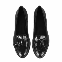 Para czarnych, lakierowanych mokasynów z frędzlami, widok z góry na białym tle.