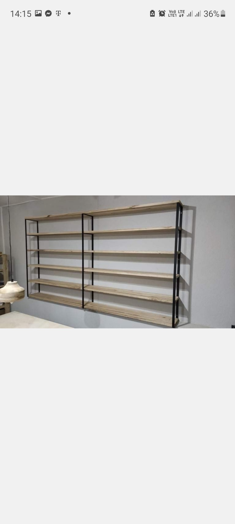 Regał ścienny z drewnianymi półkami i czarną metalową ramą, zamontowany na szarej ścianie, widoczny fragment lampy w tle.