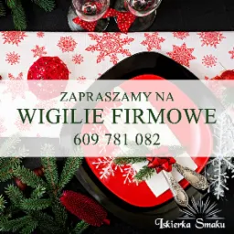 Dekoracyjny stół wigilijny z czerwonymi akcentami: talerze, serwetki z kokardą, sztućce, bieżnik w śnieżynki, bombka z wikliny i gałązki choinki, zapraszający napis na Wigilię Firmową oraz logo...