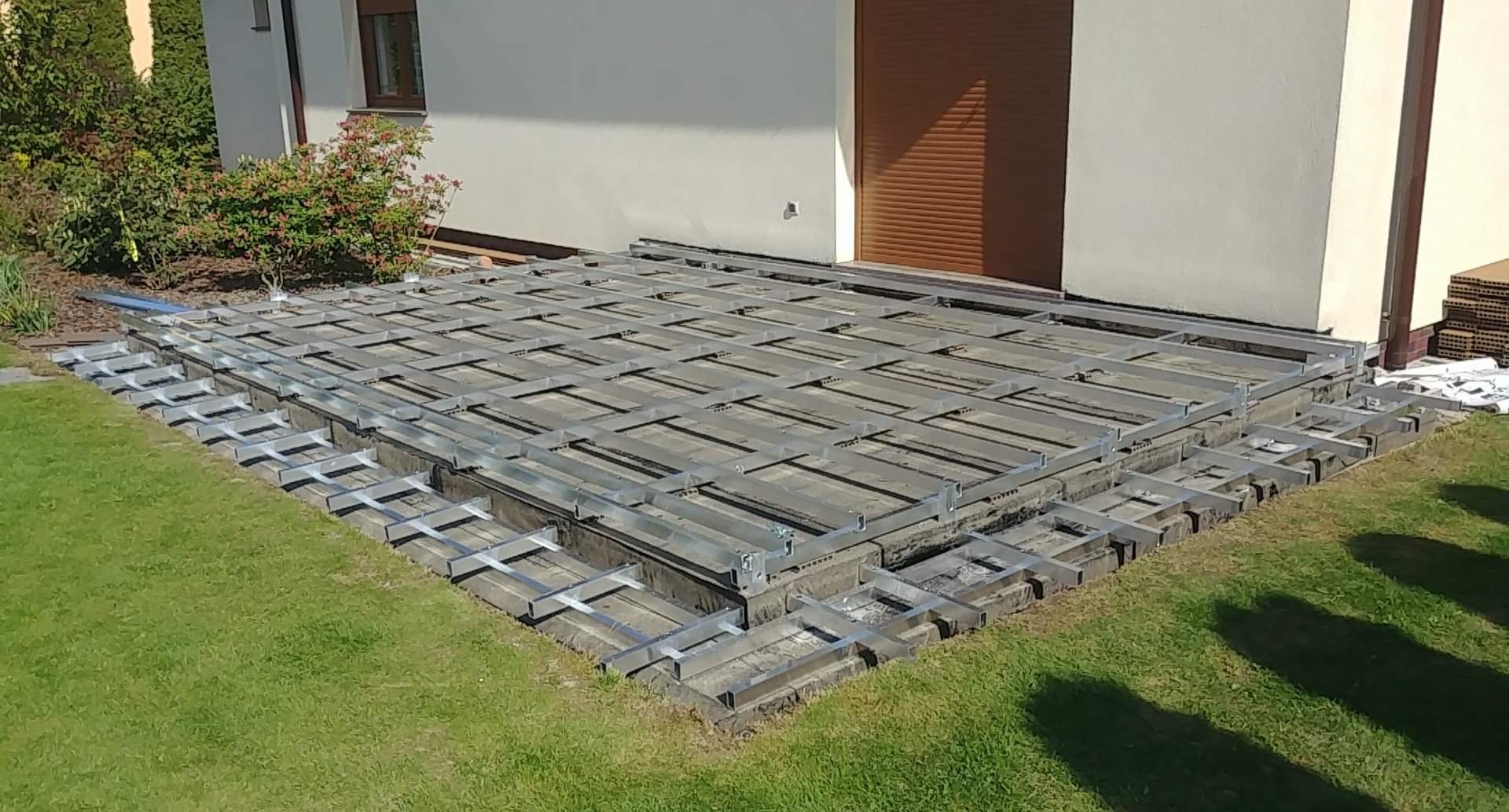 Konstrukcja z legarów aluminiowych pod deski tarasowe oraz stopnie.