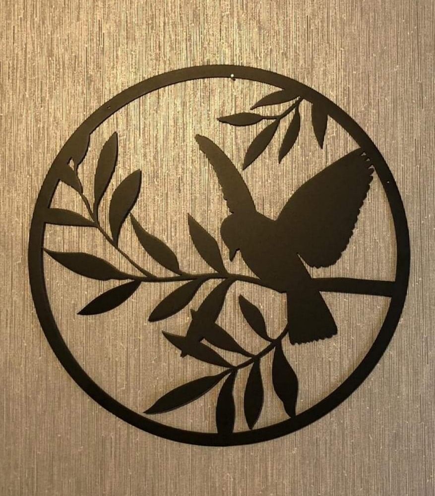 Okrągła, metalowa dekoracja ścienna przedstawiająca sylwetkę ptaka siedzącego na gałęzi z liśćmi, wykonana w stylu minimalistycznym.