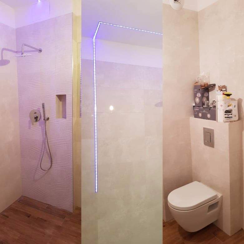 Nowoczesna łazienka z kabiną prysznicową typu walk-in, podświetleniem LED wzdłuż krawędzi szyby, drewnopodobną podłogą i wiszącą toaletą z zabudowanym stelażem, na którym stoją kosmetyki.