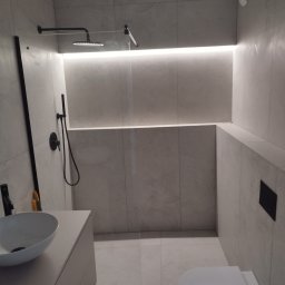 Genpro Pruchenski Grzegorz - Nowoczesna łazienka z kabiną typu walk-in, szare płytki, podświetlenie LED, czarna armatura i umywalka nablatowa. Minimalistyczny design.