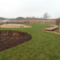 Maciej Żychowski - Nowo założony ogród z drewnianym chodnikiem, rabatami i ogrodzeniem z bambusa w Zegrzu Południowym.