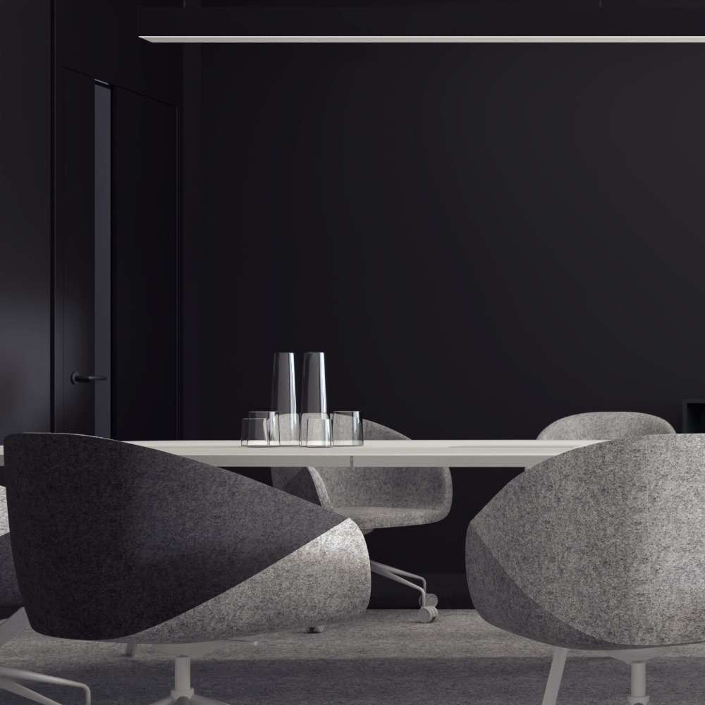 Minimalistyczna sala konferencyjna z czarnymi ścianami, białym stołem i szarymi krzesłami z filcu. Na stole szklanki o różnych kształtach.