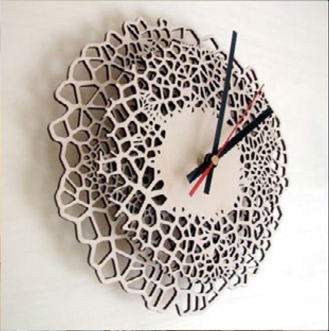 Dekoracyjny, ażurowy zegar ścienny z drewnianą ramą o nieregularnych, organicznych kształtach, czarne wskazówki i czerwony sekundnik.