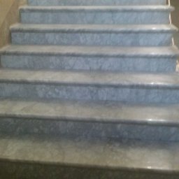 Lubarski Krzysztof - Marmurowe schody wewnętrzne z widocznymi stopniami i podstopniami, oświetlone górnym światłem.